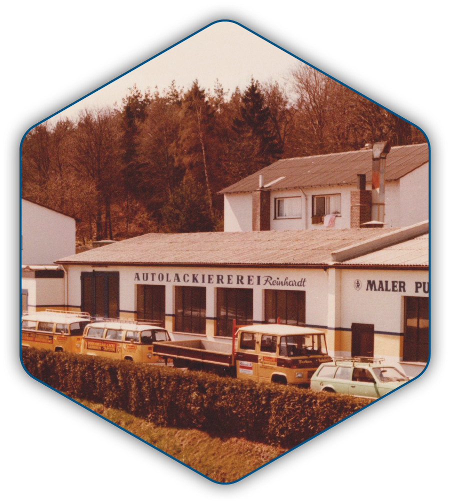 Aussenansicht der Lackiererei mit Anbau und historischem Fuhrpark
