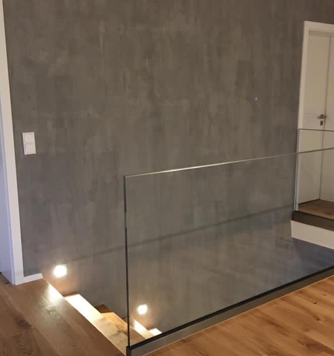 Ansicht eines Treppenabgangs mit veredelter Oberfläche der Wand in Betonoptik und Glasabtrennung