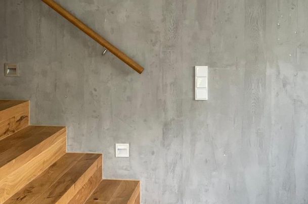 Seitliche Ansicht eines Treppenaufgangs mit veredelter Oberfläche der Wand in Betonoptik