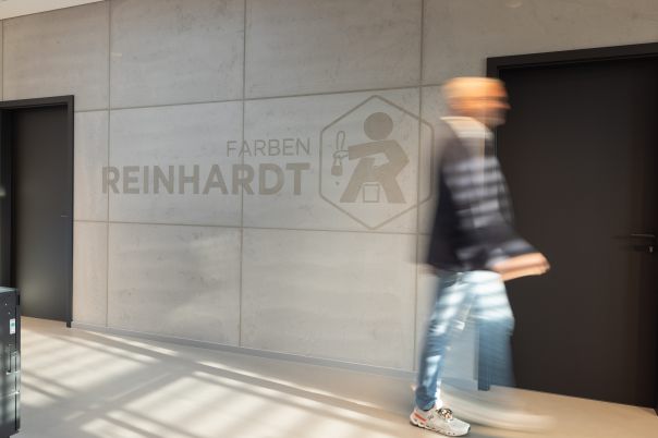 Person in Bewegungsunschärfe vor Putzwand in Betonoptik