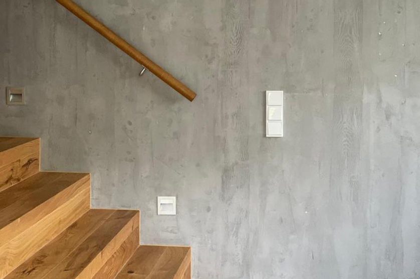 Seitliche Ansicht eines Treppenaufgangs mit veredelter Oberfläche der Wand in Betonoptik