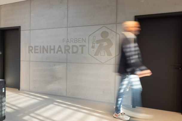 Person in Bewegungsunschärfe vor Putzwand in Betonoptik