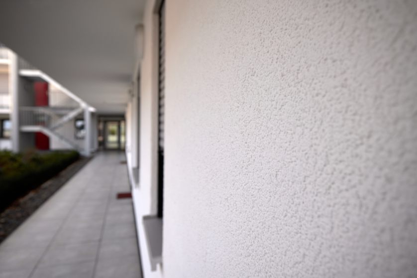 Detailansicht eines verputzten Fassadenstückes im Innenhof des Mehrfamilien-Wohngebäudes