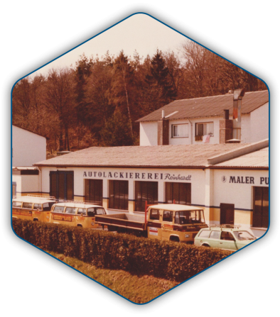 Aussenansicht der Lackiererei mit Anbau und historischem Fuhrpark